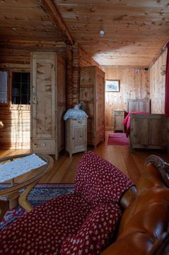 a living room with a couch in a log cabin at Hotel Villa Rina in Bormio