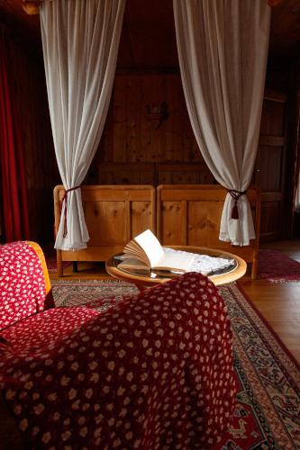 a room with a bed and a table with a book at Hotel Villa Rina in Bormio