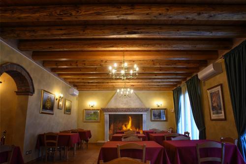 una sala da pranzo con tavoli e sedie e un camino di Agriturismo Corte Benetti a Rovigo