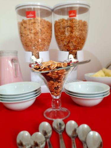 a table topped with bowls of granola and spoons at Luna de Cafayate Hotel Boutique in Cafayate