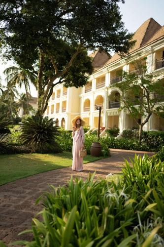a woman standing in front of a large building at Grand Hyatt Goa in Panaji