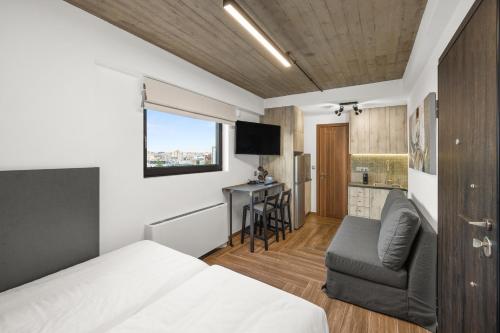 a bedroom with a bed and a chair and a kitchen at ATHENIAN VIEW LOFT in Athens
