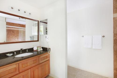 La salle de bains est pourvue d'un lavabo, d'un miroir et d'une douche. dans l'établissement Kahala 311, à Koloa