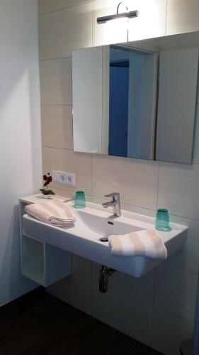 a bathroom with a sink with a mirror and towels at K3 - Appartements in Strobl
