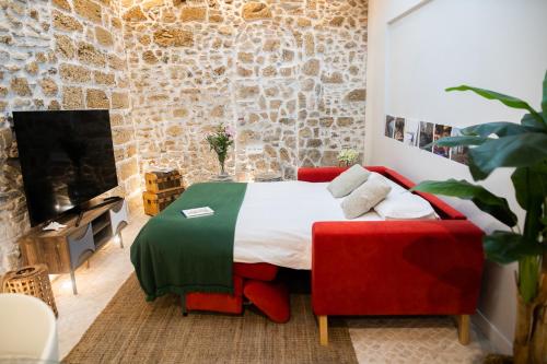 een slaapkamer met een bed en een bakstenen muur bij innCádizCASA SEÑORIAL DE 1790 in Cádiz