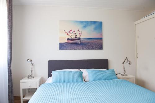a bedroom with a bed and two lamps and a painting at Gronenberger Mühle Haus 8 in Scharbeutz