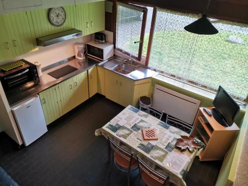 d'une cuisine avec une table. dans l'établissement Appartement cosy et fonctionnel la Bourboule, à La Bourboule