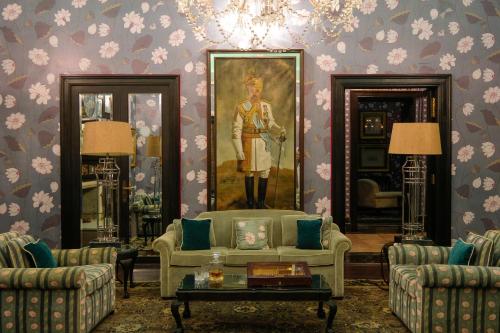 a living room with a couch and a painting on the wall at Rajmahal Palace RAAS in Jaipur