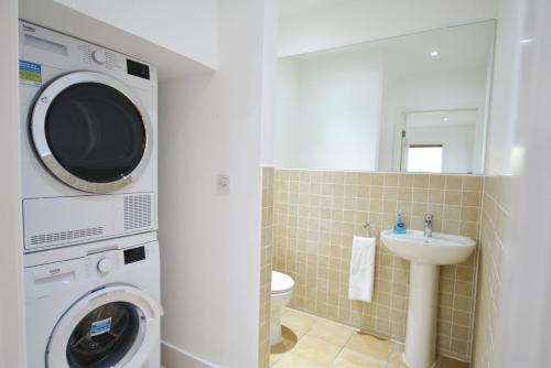a bathroom with a washing machine and a sink at Scout on the Water in South Cerney