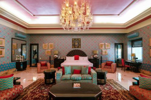 a living room with a bed and a chandelier at Rajmahal Palace RAAS in Jaipur
