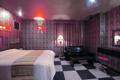 a hotel room with a bed and a chair at ホテル隠宿 凛 Rin in Ogaki