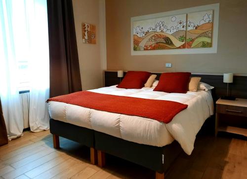 a bedroom with a large bed with red pillows at Art Hotel Pietrasanta in Pietrasanta