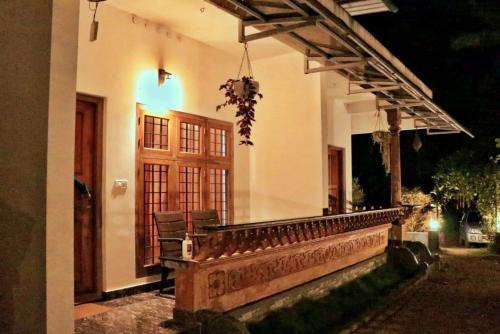 a porch of a house at night with a bench at Wild Mist Homestay in Munnar