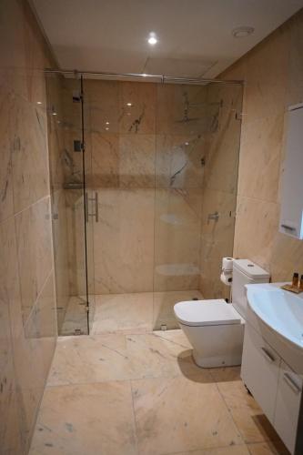 a bathroom with a shower and a toilet and a sink at Hôtel Volubilis Meknès in Meknès