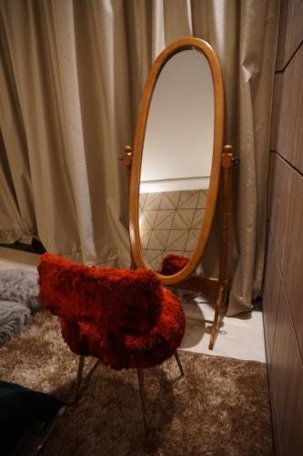a bathroom with a mirror and a red chair at Hôtel Volubilis Meknès in Meknès