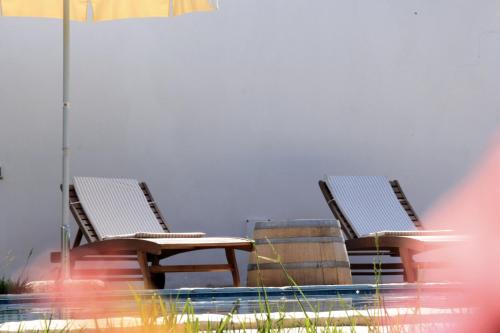 two chairs and a table next to a swimming pool at B&B Villa Giuliana in Arnesano
