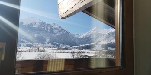 a view of a snowy mountain from a window at Haus Wenger Mountain View & Swimming Pool in Kaprun