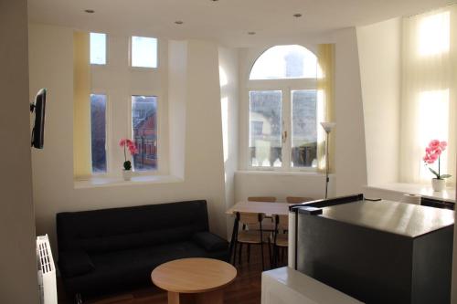 - un salon avec un canapé noir et une table dans l'établissement 4 bed city centre flat, à Liverpool