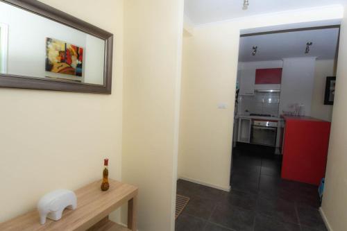 Cette chambre dispose d'une cuisine avec une table et un miroir. dans l'établissement Departamento con vista al Mar, à La Serena