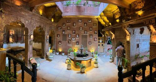 a man standing in a room with a table in a building at Rani Mahal in Jodhpur
