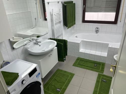 uma casa de banho branca com um lavatório, uma banheira e um WC. em Einzigartige Unterkunft mit viel Extras em Kaiserslautern
