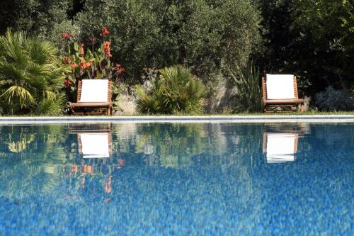 two chairs sitting next to a swimming pool at B&B Villa Giuliana in Arnesano