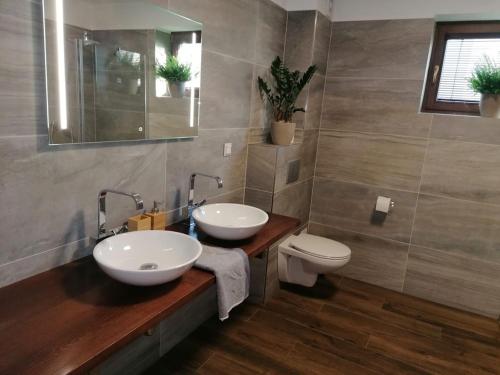 a bathroom with two sinks and a toilet at Apartmánový Dom Terchová in Terchová
