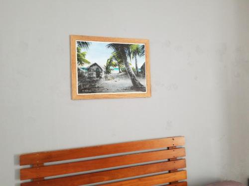 a picture hanging on a wall above a wooden bench at Ras Rana Lodge in Rasdu