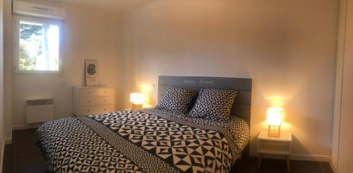 a bedroom with a bed with two lamps and a window at Le Carré des Vosges Vannes centre avec terrasse, parking privatif, Wifi in Vannes