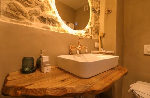 a bathroom with a white sink on a wooden counter at Në Kroi in Korçë