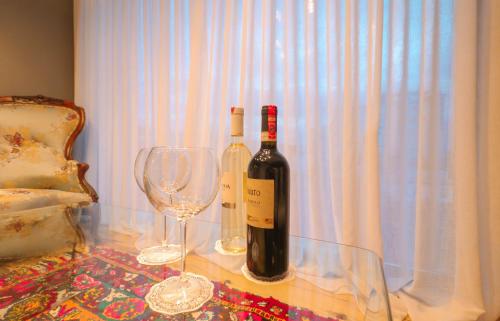 two bottles of wine and two glasses on a table at Në Kroi in Korçë