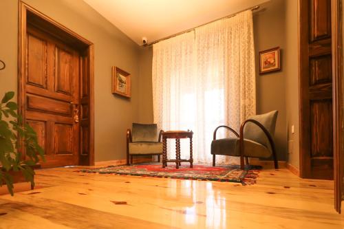 a room with a door and chairs and a window at Në Kroi in Korçë