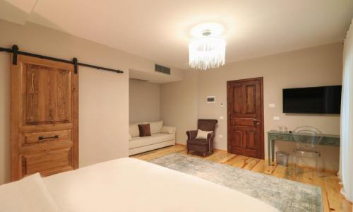 a bedroom with a bed and a couch and a television at Në Kroi in Korçë