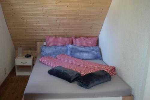 a bed with four pillows on it in a room at Ferienhaus Kühnhaide im Erzgebirge in Kühnhaide