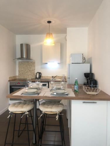 - une cuisine avec une table, des chaises et un comptoir dans l'établissement Le Carré des Vosges Vannes centre avec terrasse, parking privatif, Wifi, à Vannes