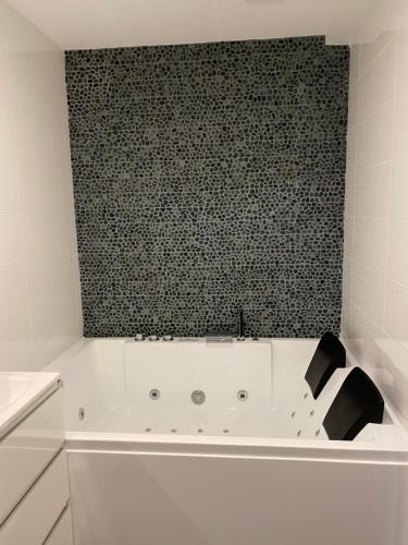 a bath tub in a bathroom with a black wall at Le Gîte de Lancelot avec balnéo City Center in Sens