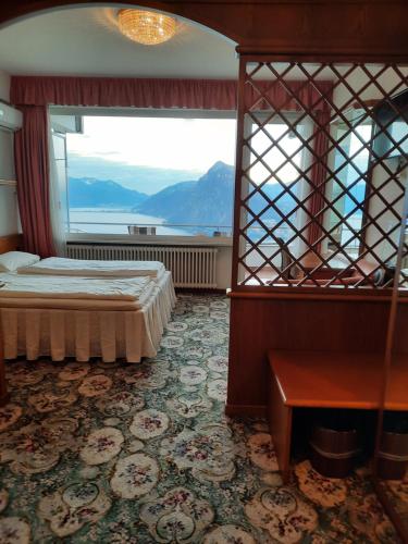 a bedroom with a bed and a large window at Hotel Colibrì in Lugano