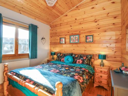 a bedroom with a bed in a log cabin at Osprey Lodge in Tattershall