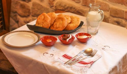 a table with a plate of onion rings and a bowl of food at Në Kroi in Korçë