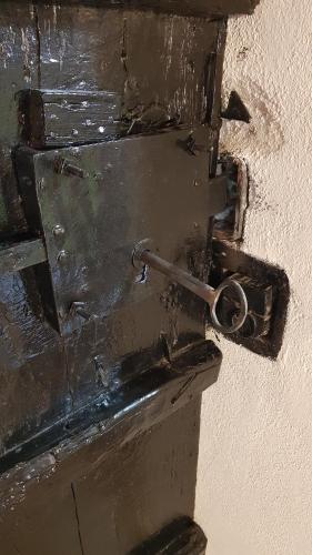 a black door with a metal handle on a wall at Archontiko Mansion Porteli Αρχοντικο Πορτελι in Makrinítsa
