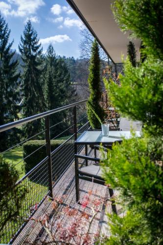 a balcony with a table and a view of the forest at Restaurant Hôtel L'Arnsbourg in Baerenthal