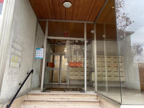 uma entrada para um edifício com portas de vidro e escadas em LE CARDINAL, appartement avec parking privé, gare, centre ville, em Annecy