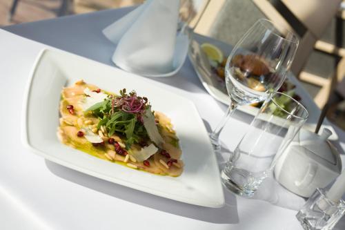 a plate of food on a table with a glass of wine at Hotel Jastarnia in Jastarnia