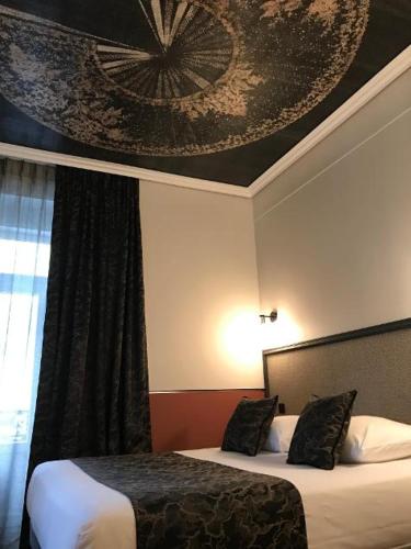 a hotel room with two beds and a painting on the wall at Le Grand Hôtel Mont Dore in Le Mont-Dore