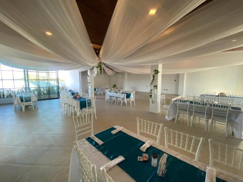 a banquet hall with white tables and chairs at Hotel Celeste Inn Chinauta- Fusagasugá in Chinauta