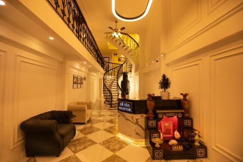 a hallway with a couch and a chair in a room at Phước Hưng 2 Hotel in Vĩnh Long