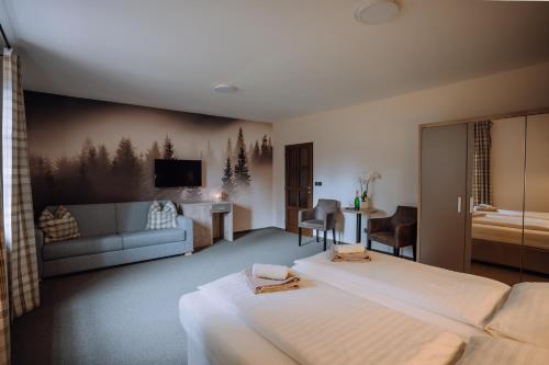 ドルニー・モラヴァにあるPod Slamníkemのベッド2台とリビングルームが備わるホテルルームです。