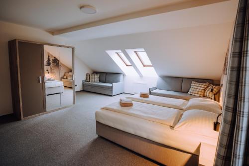 a bedroom with a large bed and a couch at Pod Slamníkem in Dolní Morava