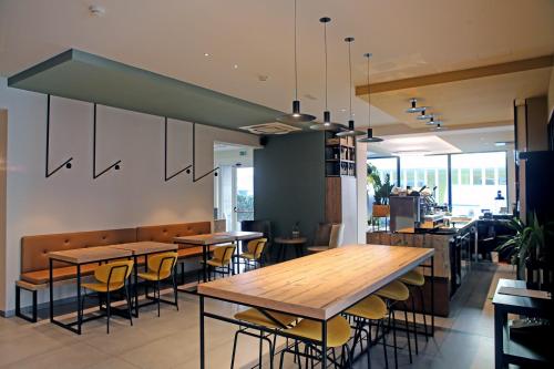 a restaurant with wooden tables and stools in it at Meg Lifestyle Hotel & Apartaments in Riccione