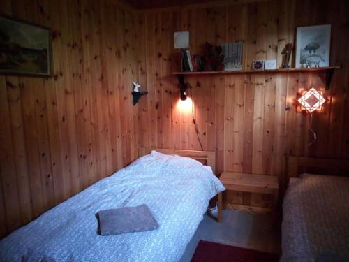 um quarto com uma cama numa parede de madeira em Guesthouse Simolle em Hammarstrand